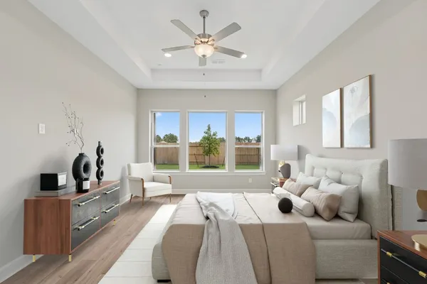 a bedroom with furniture and a large window