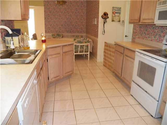 780 Southwest Ancona Road Port St. Lucie, FL 34953 - Photo 4 of 7 a kitchen with a sink stove and cabinets