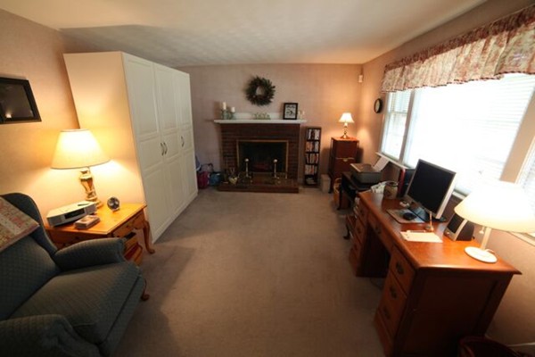 99 Spallus Road Stoughton, MA 02072 - Photo 13 of 14 a living room with furniture a fireplace and a flat screen tv