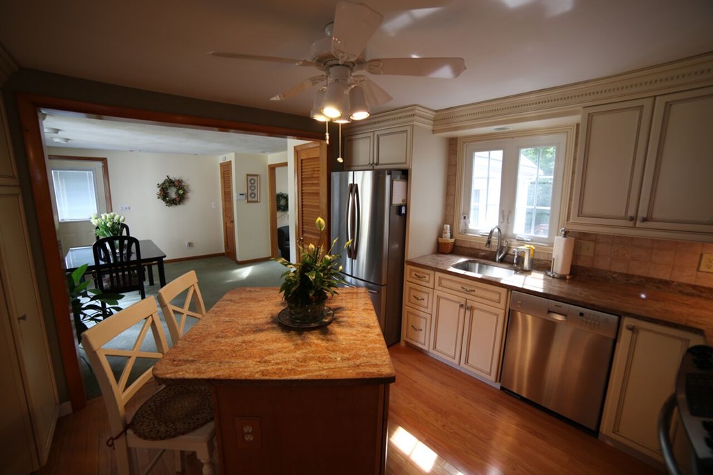 99 Spallus Road Stoughton, MA 02072 - Photo 4 of 14 a kitchen with granite countertop sink table and chairs