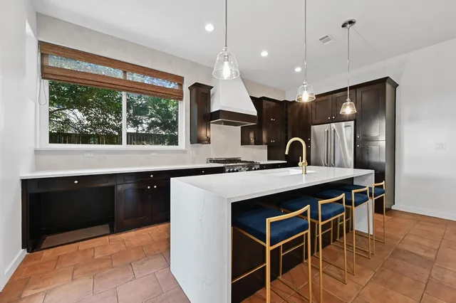 a kitchen with stainless steel appliances granite countertop a sink a stove and a refrigerator