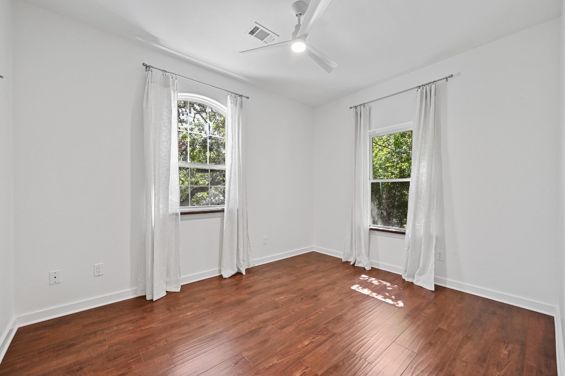2705 Bonnie Road, Unit A Austin, TX 78703 - Photo 10 of 18 an empty room with wooden floor cabinet and windows