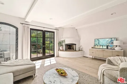 a view of a patio with a table chairs and a barbeque