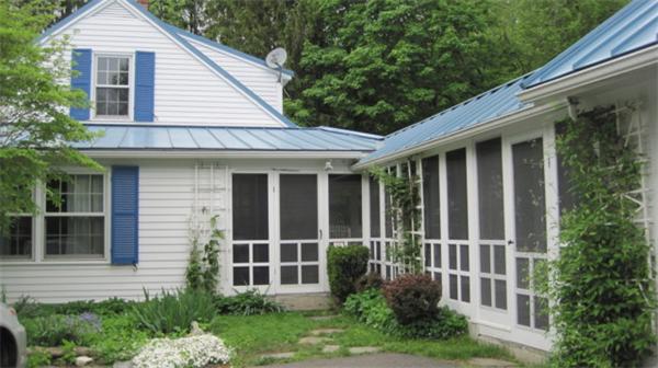 75 Amherst Road Leverett, MA 01054 - Photo 14 of 22 a view of a brick house with a large window plants and large trees