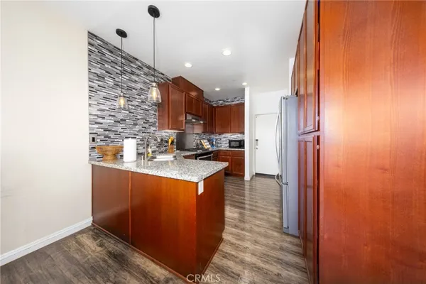 a kitchen with granite countertop a sink and a refrigerator
