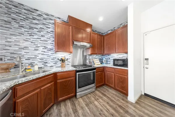 a kitchen with stainless steel appliances granite countertop a sink stove and refrigerator