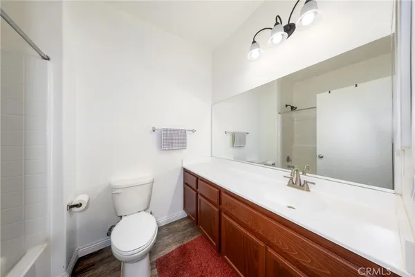 a bathroom with a sink a toilet a mirror and shower