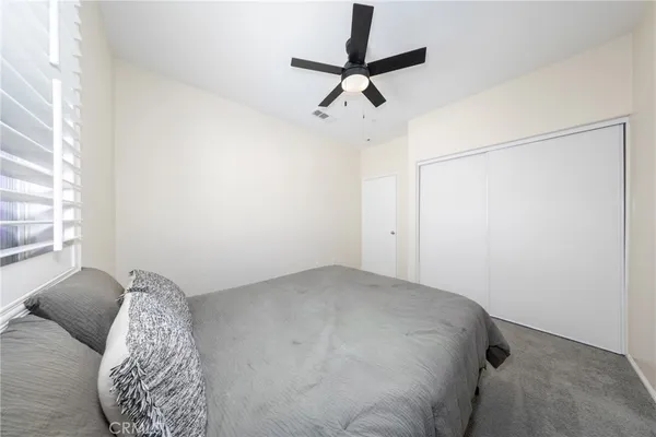 a bedroom with a bed and a chandelier fan