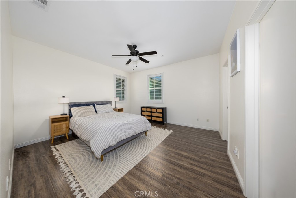 12068 Preston Street Grand Terrace, CA 92313 - Photo 24 of 34 a spacious bedroom with a bed and a chandelier