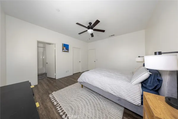 a bedroom with a bed and a lamp on the dresser
