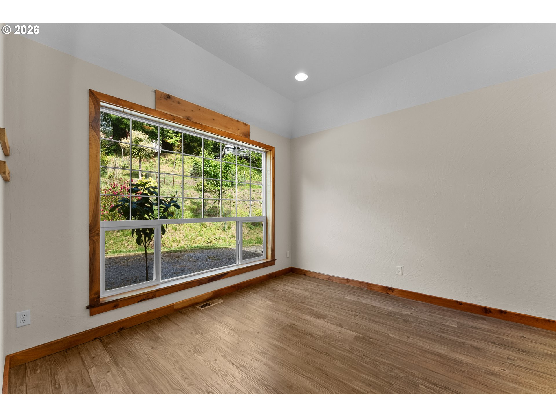 16711 Thompson Road Brookings, OR 97415 - Photo 16 of 45 a view of an empty room with wooden floor and a window