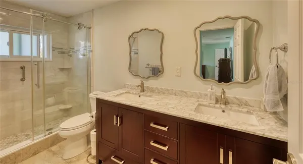 a bathroom with a double vanity sink toilet and shower