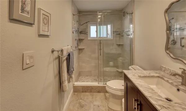 a bathroom with a granite countertop sink toilet and shower