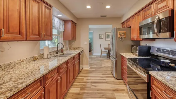 a kitchen with granite countertop a sink stove and cabinets