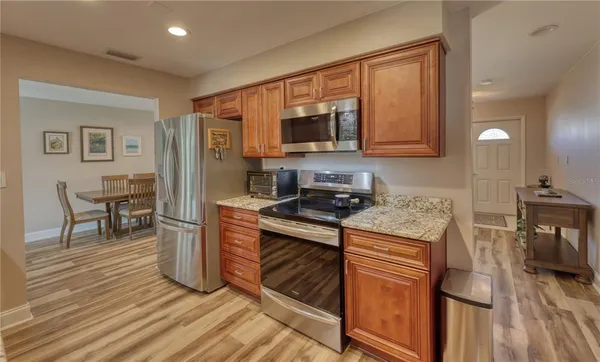 a kitchen with stainless steel appliances granite countertop a stove a sink and a refrigerator
