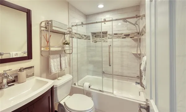 a bathroom with a bathtub shower sink vanity and toilet
