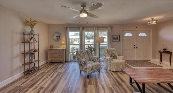 a living room with furniture a window and wooden floor
