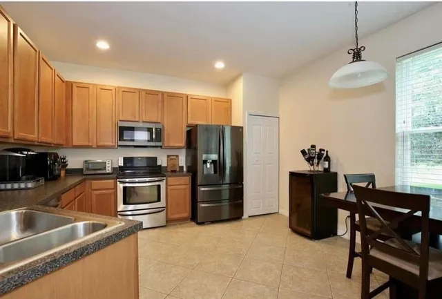 a kitchen with stainless steel appliances granite countertop a refrigerator and a stove top oven