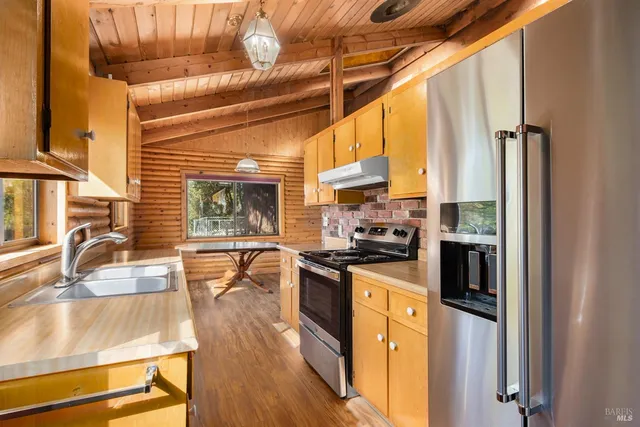 a kitchen with stainless steel appliances granite countertop a stove a sink and a refrigerator