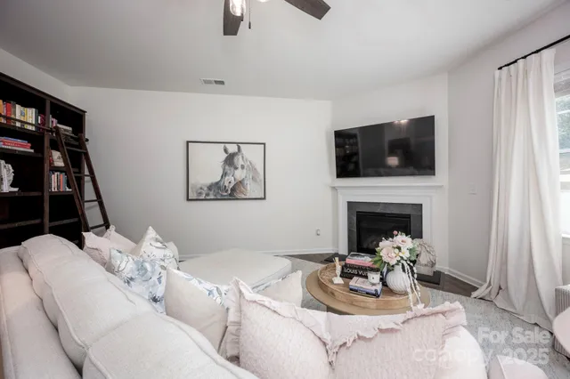 a living room with furniture a flat screen tv and a fireplace