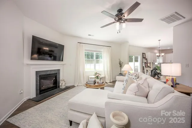 a living room with furniture a flat screen tv and a fireplace