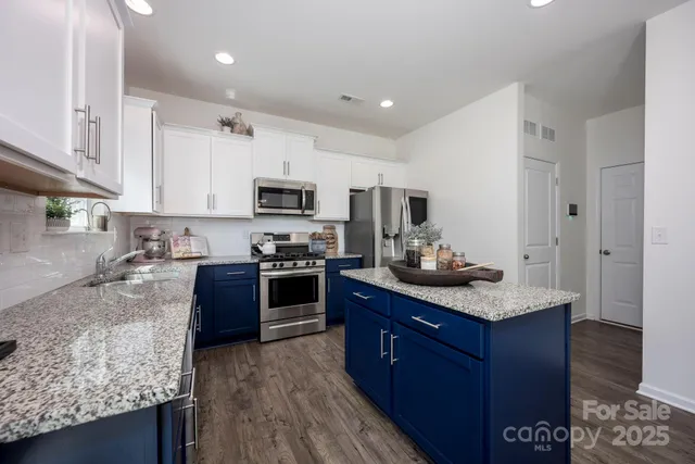 a kitchen with granite countertop stainless steel appliances and wooden cabinets