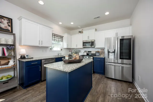 a kitchen with kitchen island granite countertop stainless steel appliances and a sink