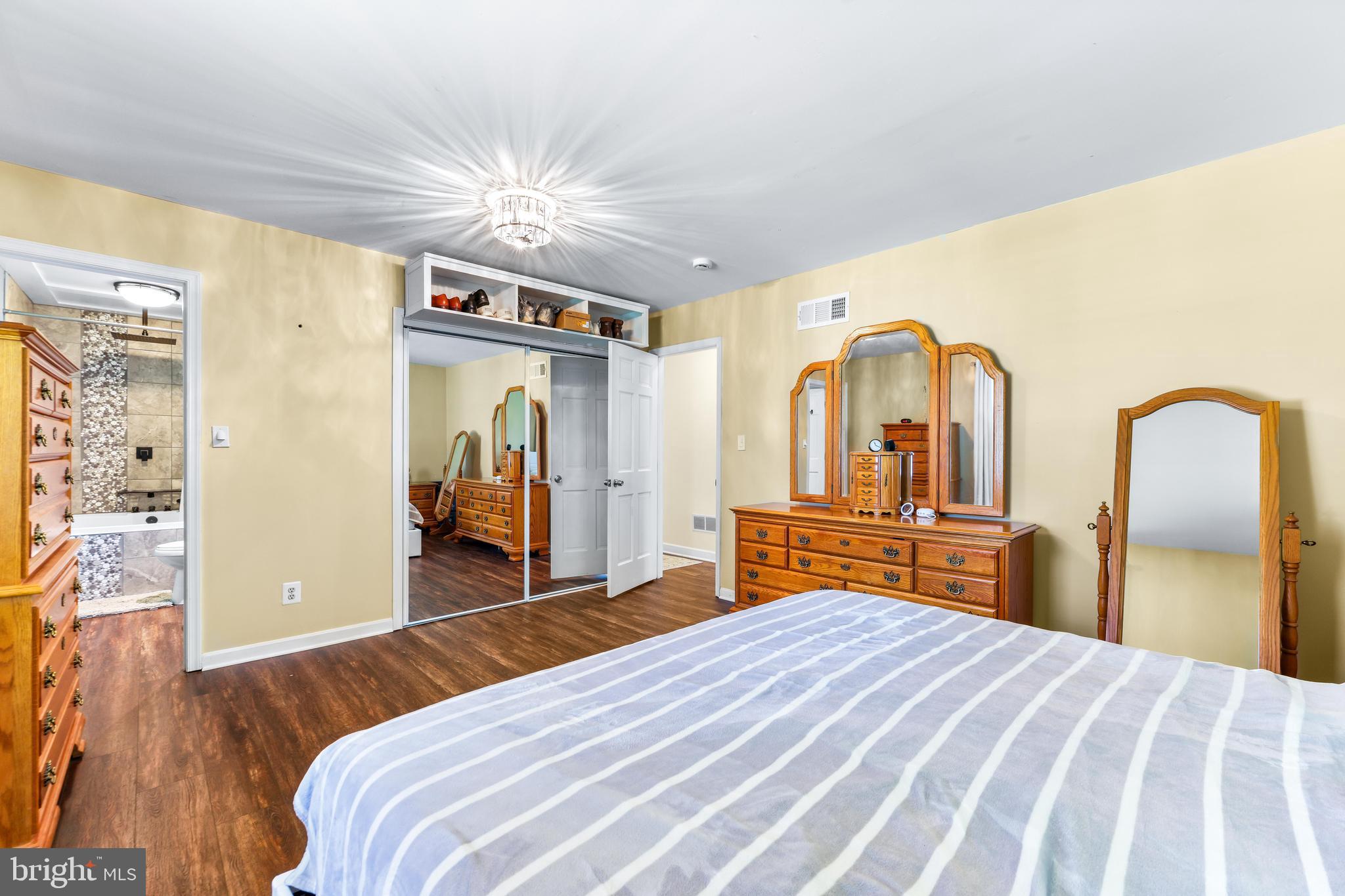2847 Moores Road Baldwin, MD 21013 - Photo 39 of 73 a bedroom with a bed and a large mirror with a chandelier