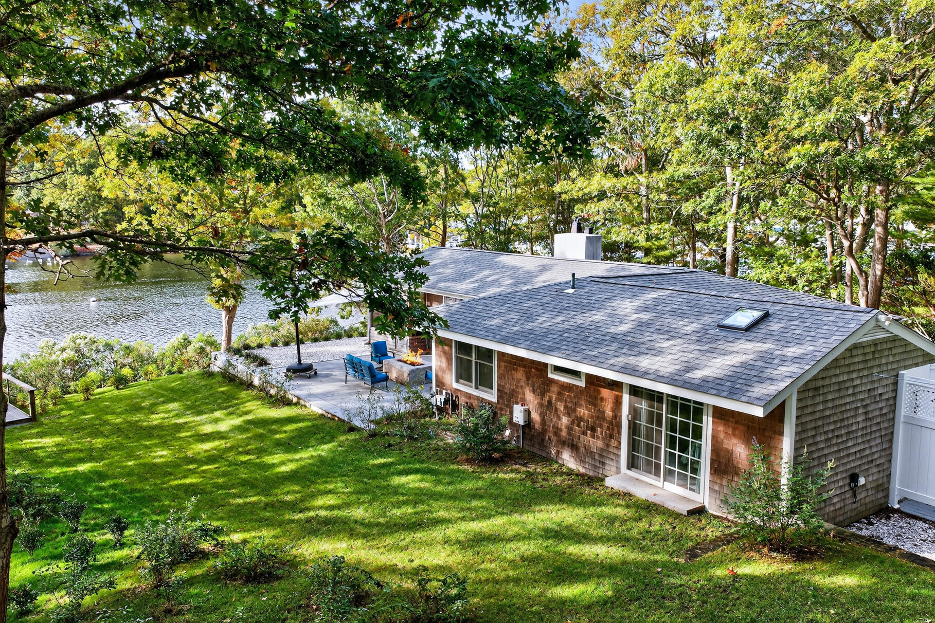 23 Childs River Road East Falmouth, MA 02536 - Photo 30 of 34 a backyard of a house with table and chairs large trees