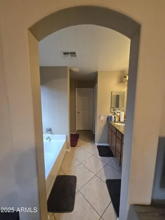 a spacious bathroom with a tub sink and mirror