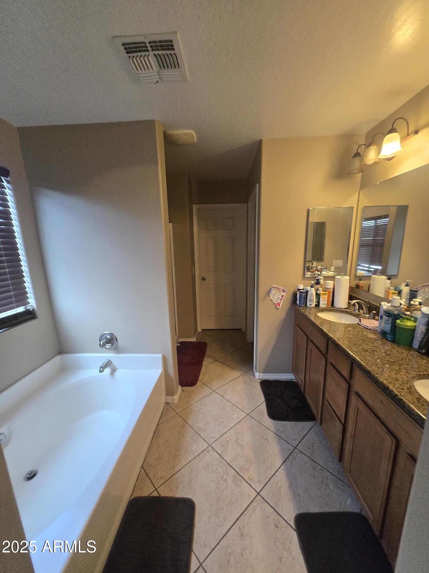 8814 West Magnolia Street Tolleson, AZ 85353 - Photo 14 of 19 a spacious bathroom with a tub sink and mirror