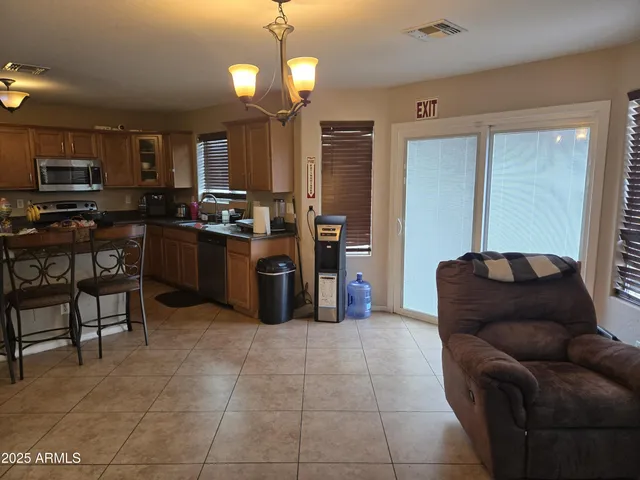 a living room with furniture a flat screen tv and kitchen view
