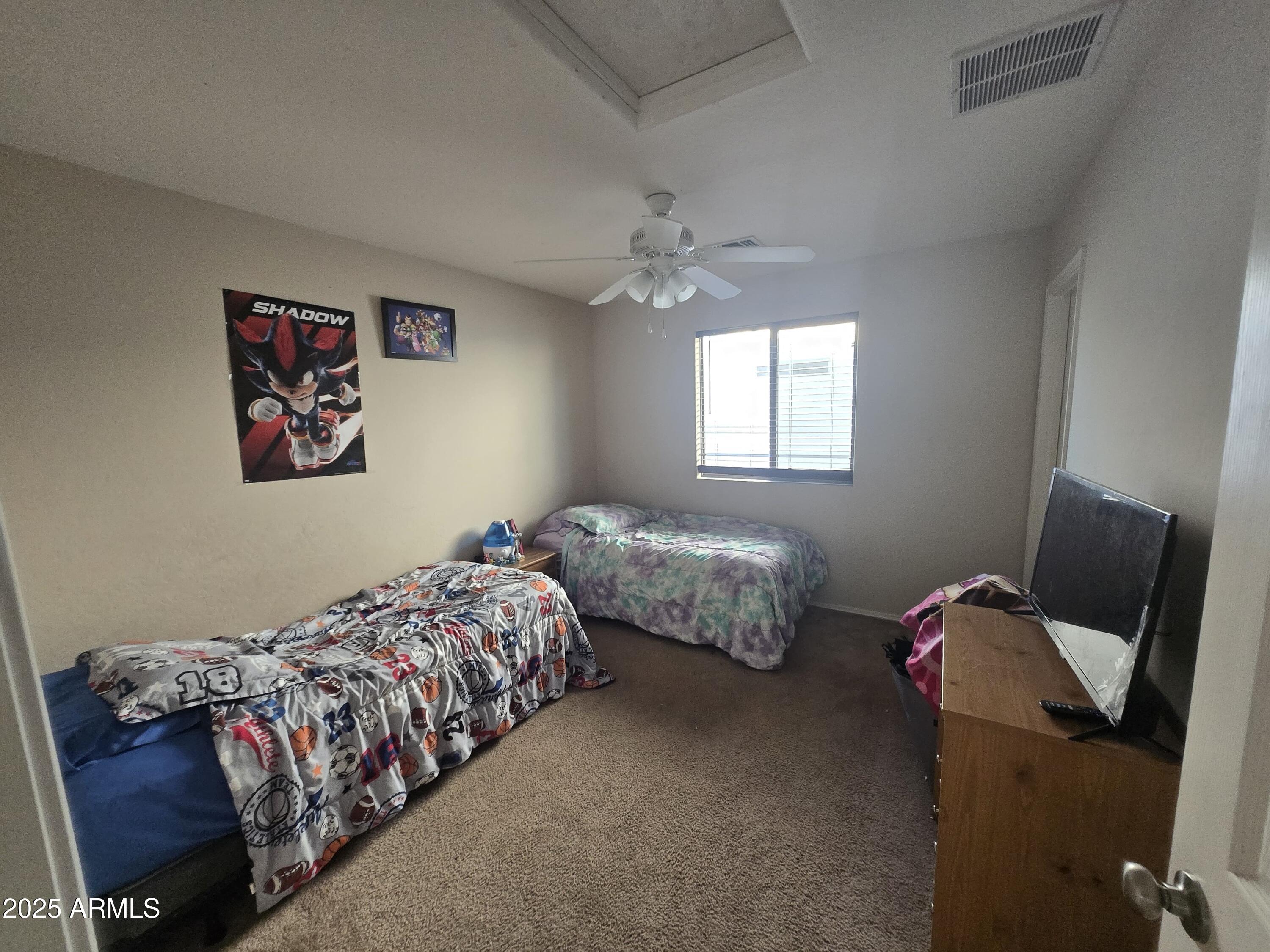 8814 West Magnolia Street Tolleson, AZ 85353 - Photo 8 of 19 a bedroom with two beds and a chair