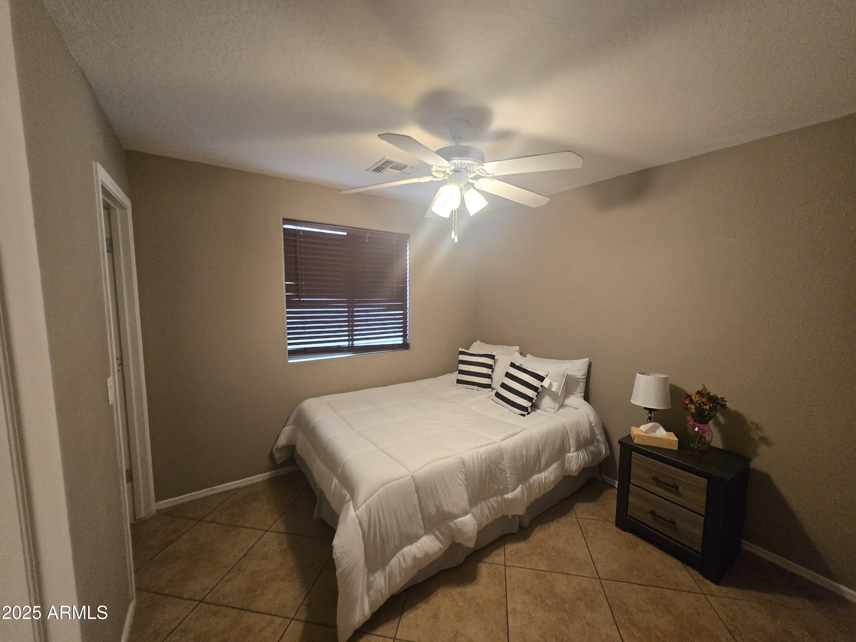 8814 West Magnolia Street Tolleson, AZ 85353 - Photo 9 of 19 a bedroom with a bed and a chandelier