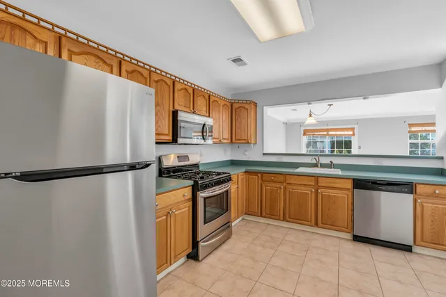a kitchen with stainless steel appliances granite countertop a refrigerator sink and white cabinets