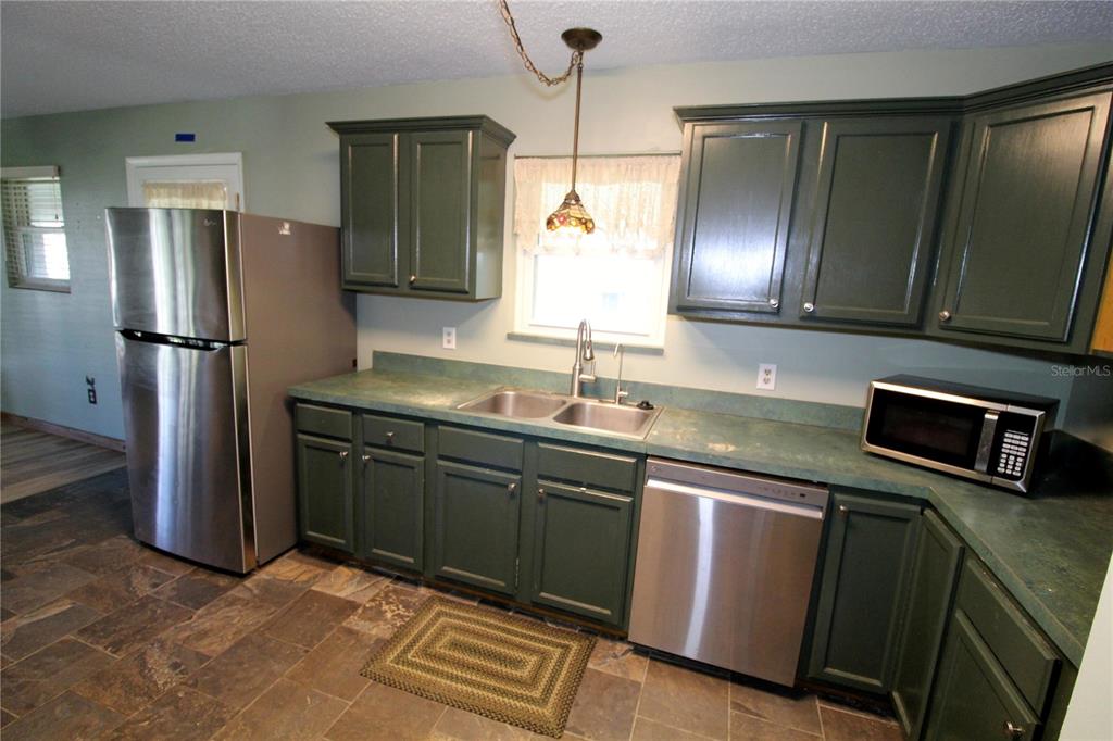 14712 Henson Road Orlando, FL 32832 - Photo 10 of 32 a kitchen with stainless steel appliances granite countertop a refrigerator and a sink