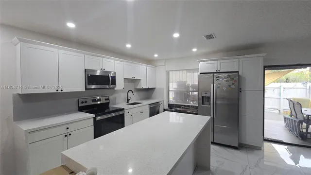 a kitchen with stainless steel appliances a refrigerator stove microwave and sink