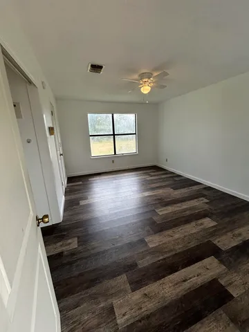 wooden floor in an empty room with a window