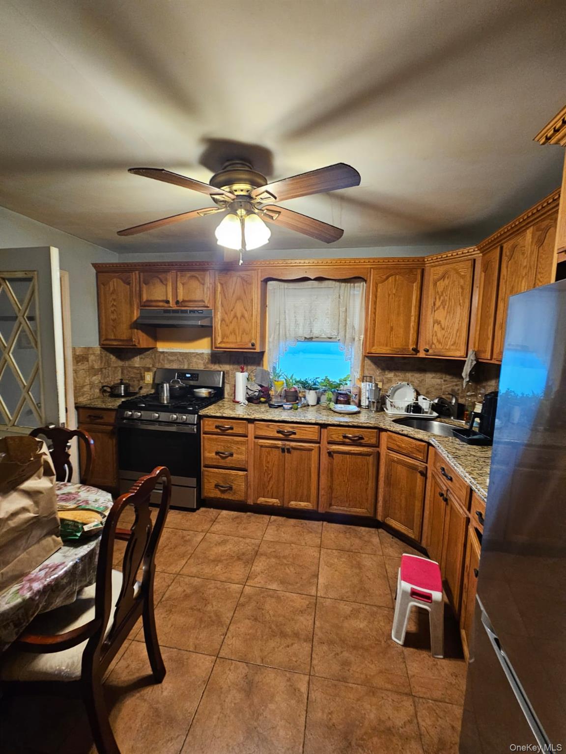 49 Volta Street Copiague, NY 11726 - Photo 5 of 9 a kitchen with stainless steel appliances kitchen island granite countertop a stove a sink and a microwave