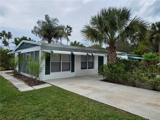 a view of a house with a yard and potted plants