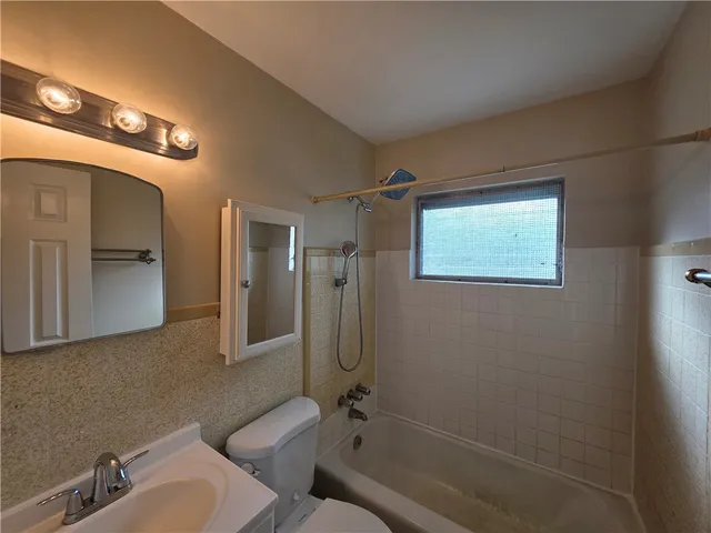 a bathroom with a granite countertop sink mirror and toilet