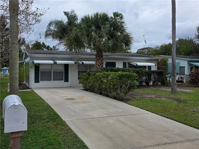 a front view of a house with a garden and plants