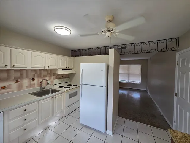 a kitchen with white cabinets and white appliances