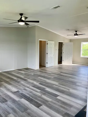 a view of a room with wooden floor and ceiling fan