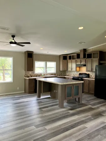 a kitchen with kitchen island a sink appliances and cabinets