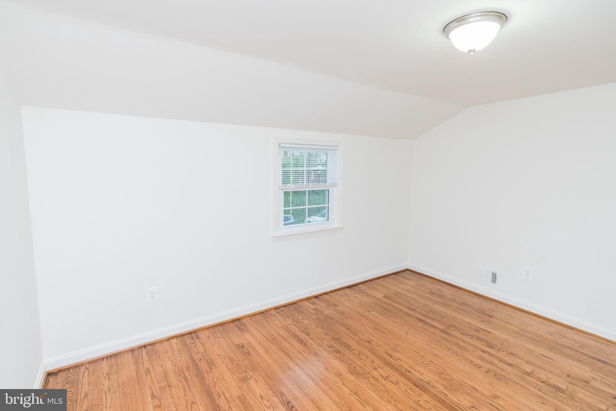 1613 Neely Road Silver Spring, MD 20903 - Photo 34 of 53 an empty room with wooden floor and windows
