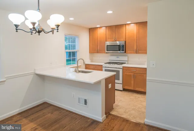 a kitchen with a sink cabinets and wooden floor
