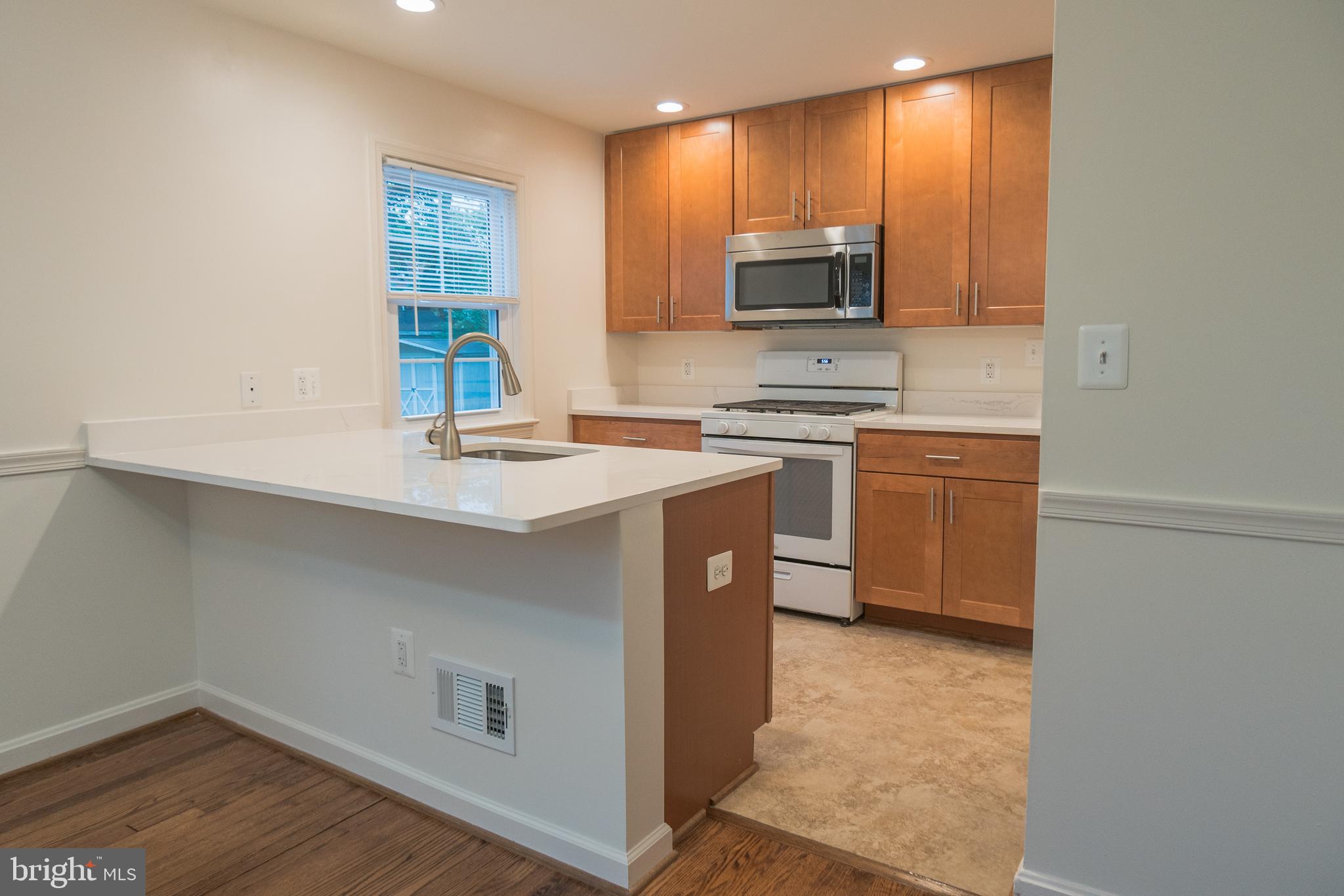 1613 Neely Road Silver Spring, MD 20903 - Photo 10 of 53 a kitchen with stainless steel appliances a sink a stove a microwave a sink a refrigerator and cabinets