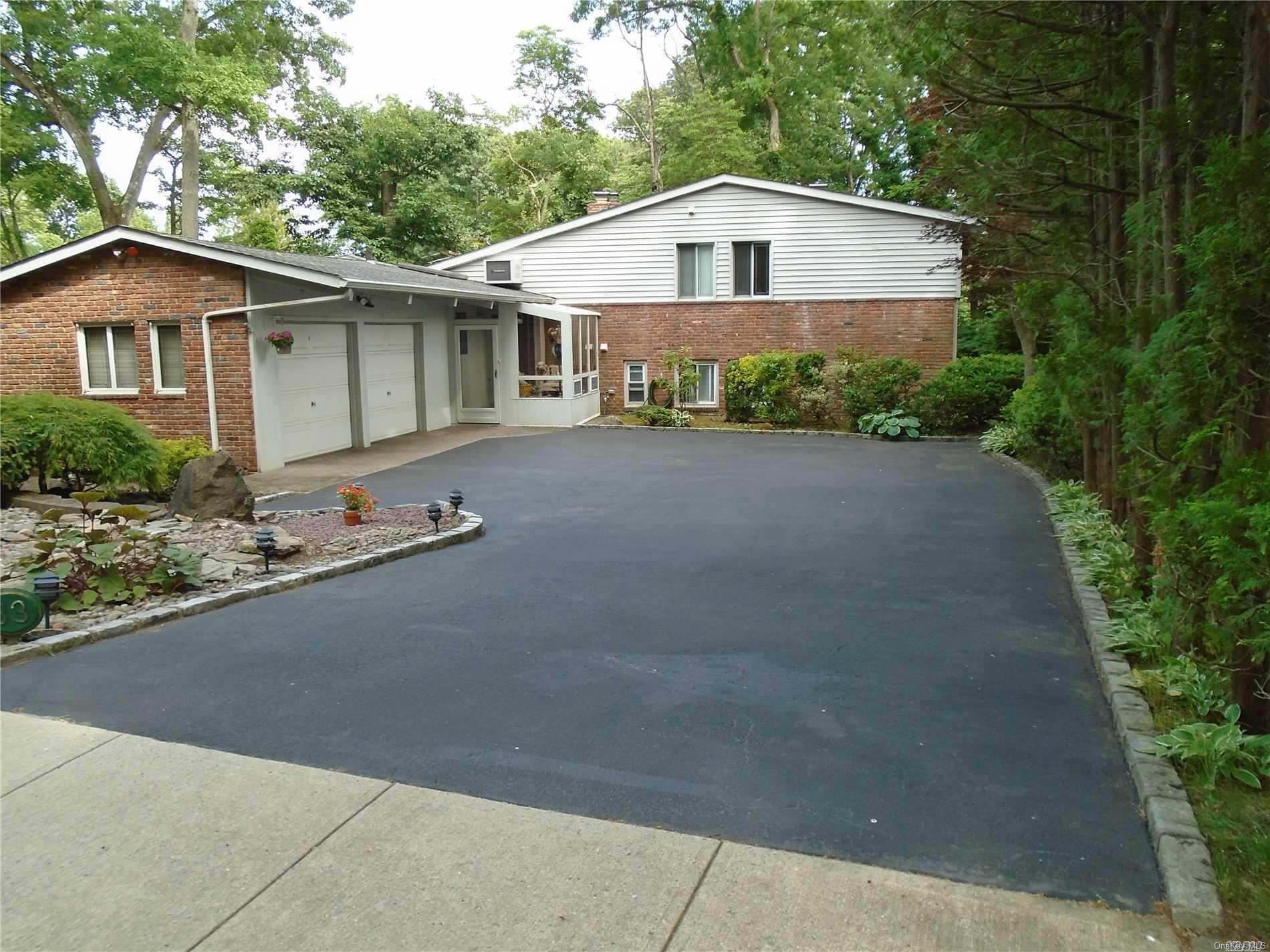 33 Highwood Road East Norwich, NY 11732 - Photo 1 of 1 a front view of a house with a yard and garage