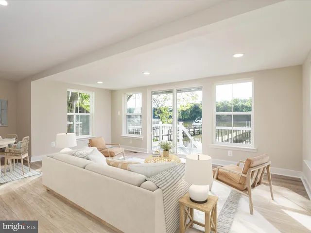 a living room with furniture white walls and kitchen view